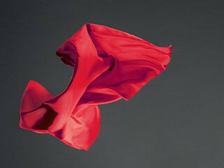 red fabric in the air against dark background
